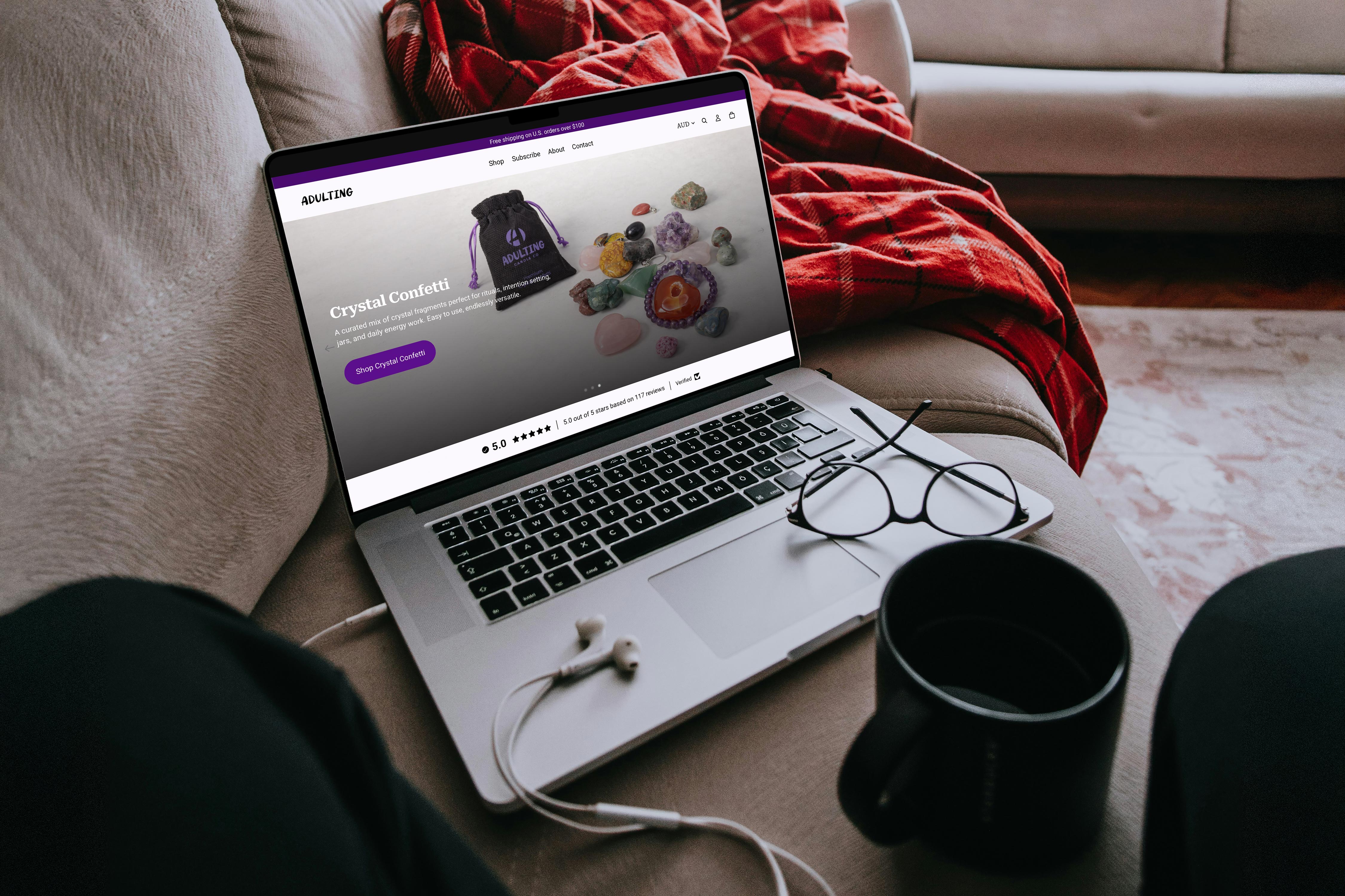 Adulting Candle Co. Shopify site shown on a laptop